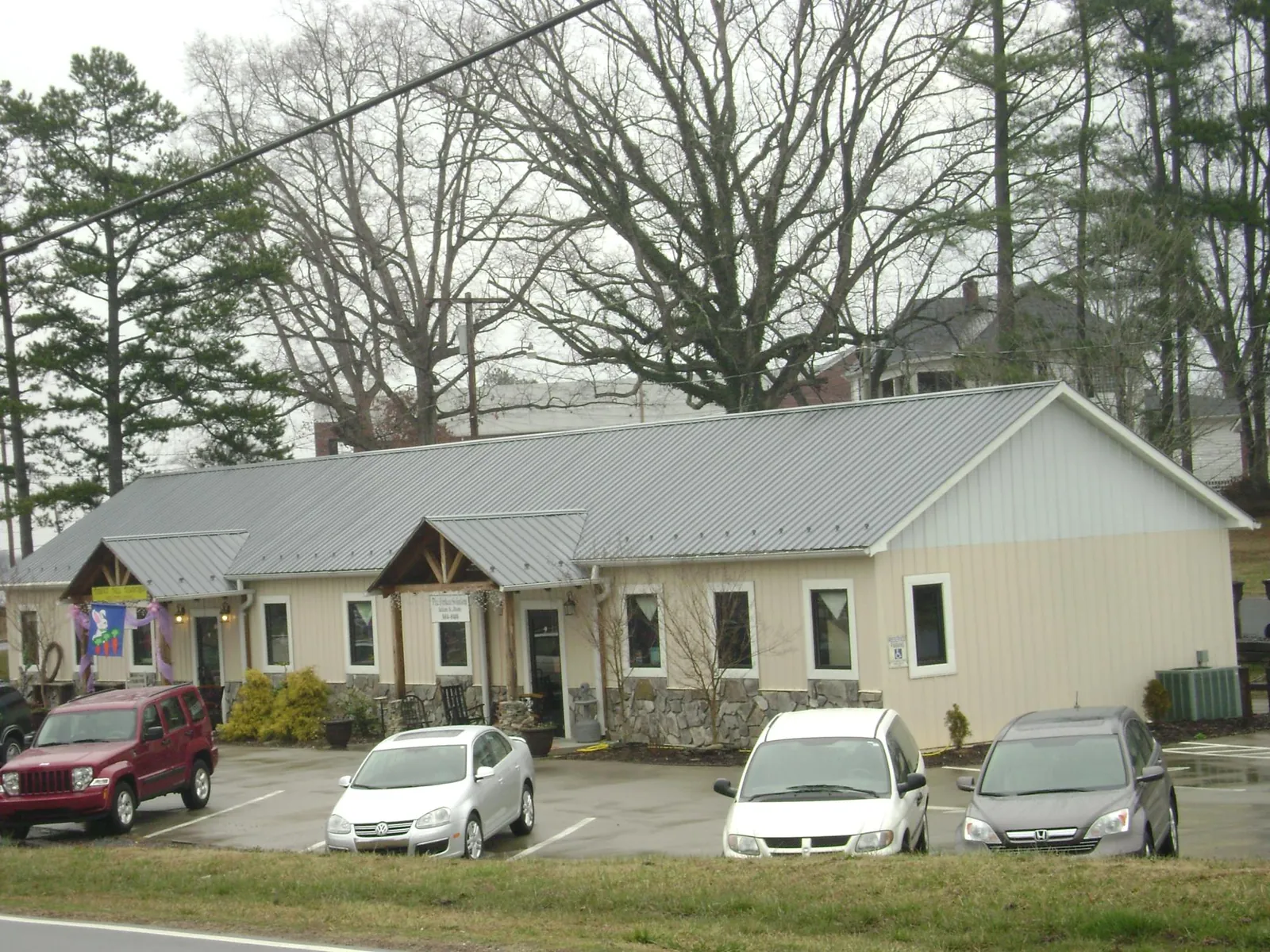 Gray metal roof with timber entry brackets on a small commercial building in Jackson